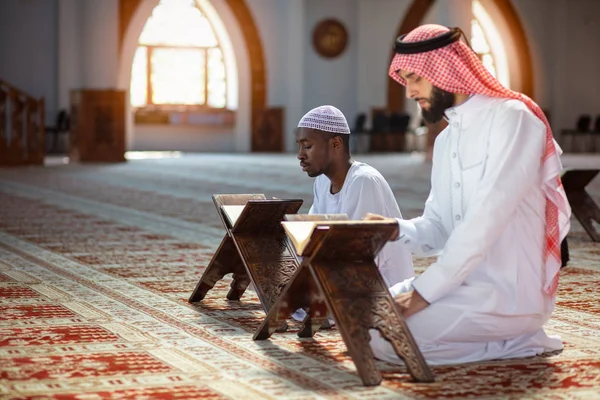 Muslim men praying with holy books in mosque — Stock Photo, Image