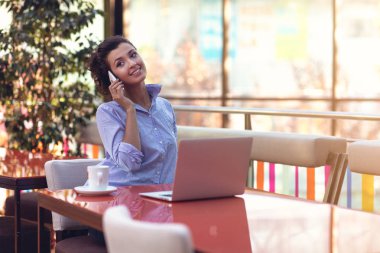 Kahve dükkanında çalışırken telefonu kullanarak iş kadını