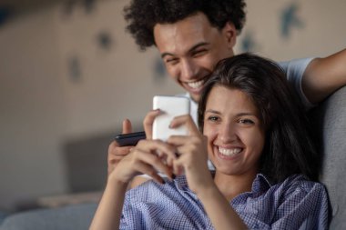 smartphone evde oturma odasında birlikte bakarak kanepede oturan çekici çift