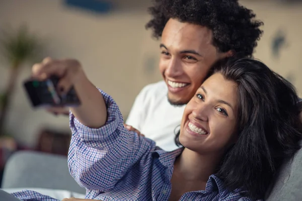 Jovem casal negro relaxante no sofá e sorrindo para a câmera — Fotografia de Stock