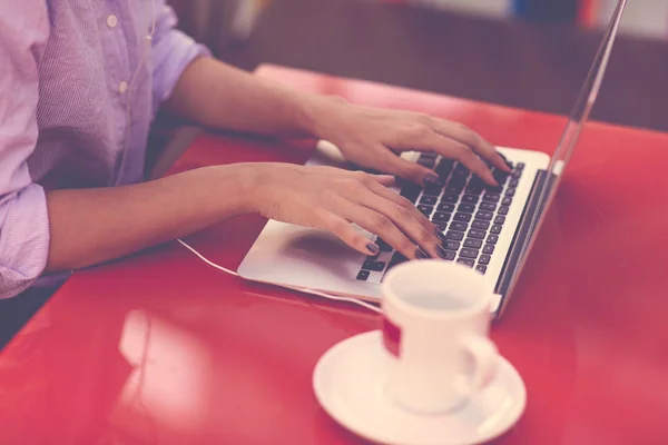 Руки женщины, печатающей на клавиатуре ноутбука. Женщина, работающая на ноутбуке в кафе . — стоковое фото