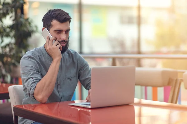 Freelancer barbudo feliz animado lendo e-mail com resultados sobre a vitória no concurso online moderno sentado no computador portátil à mesa . — Fotografia de Stock