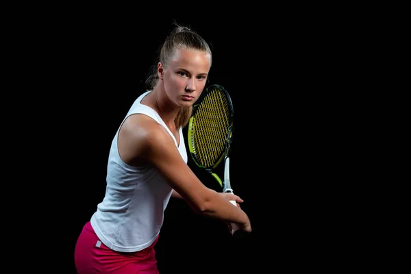 Retrato de una hermosa mujer jugando al tenis en el interior. Aislado en negro . — Foto de Stock