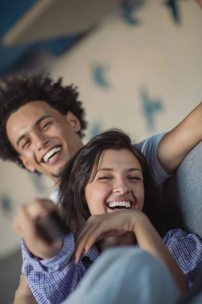 Joven pareja negra relajándose en el sofá y sonriendo a la cámara — Foto de Stock