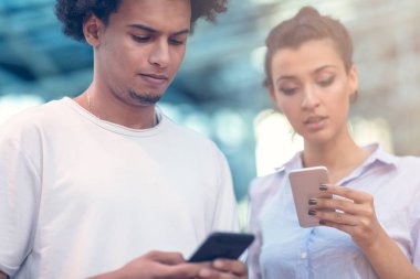 Genç adam uzakta üstünde hareket eden telefon kafede konuşurken arıyorsunuz
