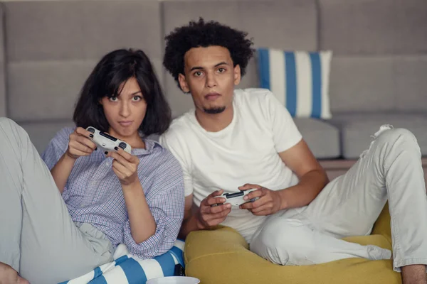 Jovem casal brincalhão jogando videogames em sua sala de estar . — Fotografia de Stock