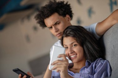 smartphone evde oturma odasında birlikte bakarak kanepede oturan çekici çift