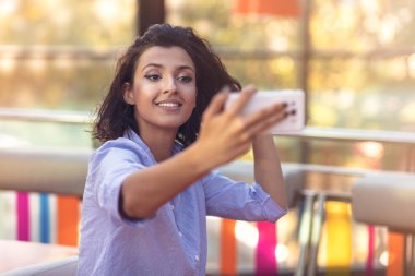 Genç kadın kahve dükkanında bir selfie alarak