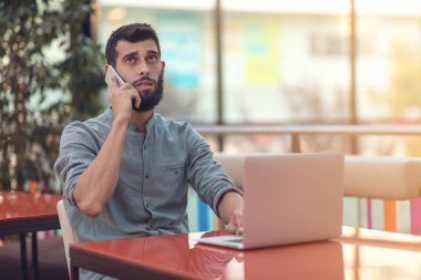 Modern online yarışma dizüstü bilgisayar masasında oturan zafer hakkında sonuçları ile mutlu sakallı freelancer okuma e-posta heyecanlı.