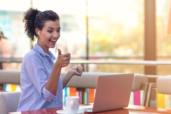 Giovane attraente ragazza razza mista che sorride guardando il suo schermo del computer portatile durante la videochiamata — Foto Stock