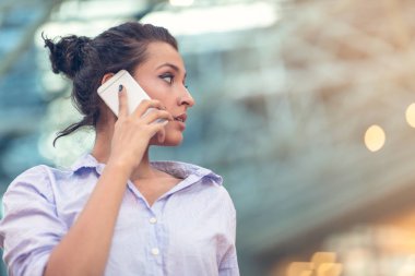 Genç kadın arama ile meşgul cep telefonu yan görünüm portre üzerinde sohbet.