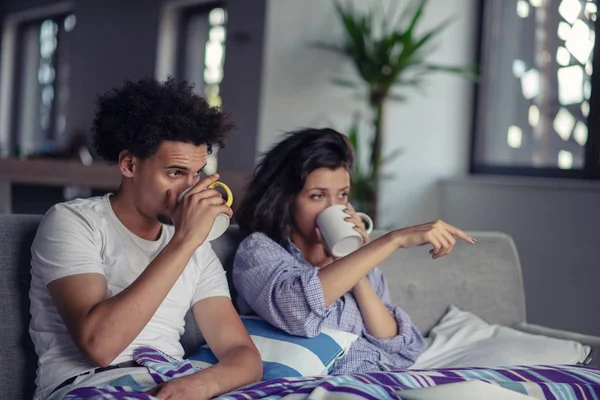 Jovem casal assistindo um filme em seu laptop na cama — Fotografia de Stock