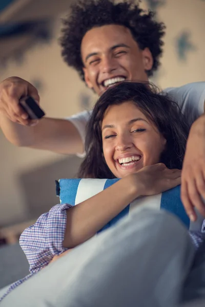 年轻的黑人夫妇在沙发上放松, 对着镜头微笑 — 图库照片