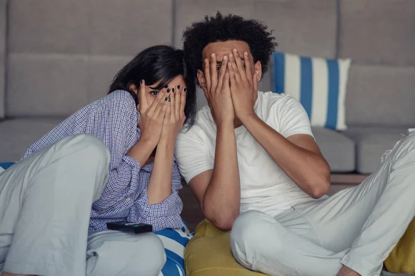 Jovem casal em casa assistindo a um filme com pipocas — Fotografia de Stock