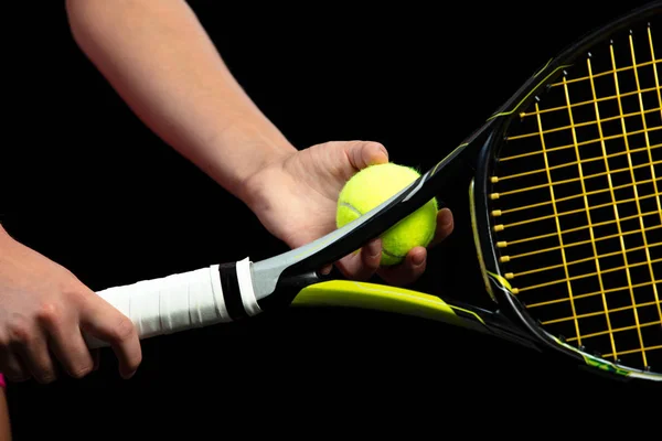 Una joven practicando tenis. Jugador principiante sosteniendo una raqueta, aprendiendo habilidades básicas. Retrato sobre fondo negro . — Foto de Stock