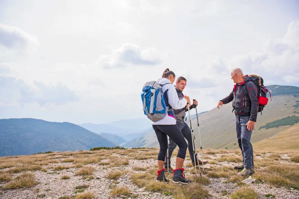 An elderly man giving a tour for a young group of people — Stock Photo, Image