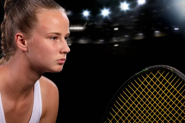 Vacker flicka tennisspelare med en racket på mörk bakgrund med ljus — Stockfoto