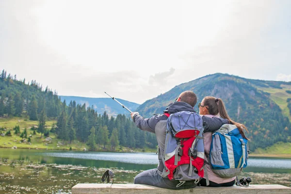 Молода пара рюкзаків біля озера в горах — стокове фото