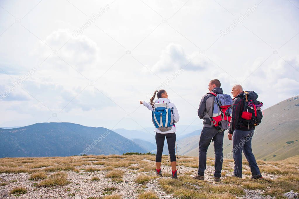 An elderly man giving a tour for a young group of people