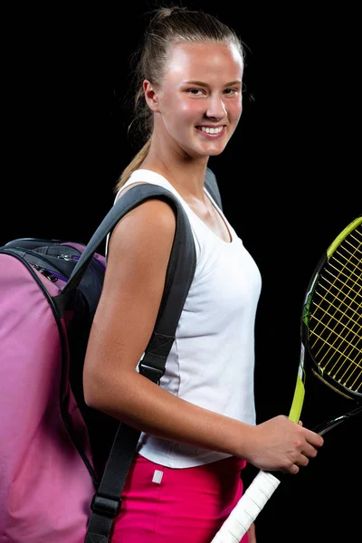 Atleta femenina posando con raqueta de tenis sobre fondo negro — Foto de Stock