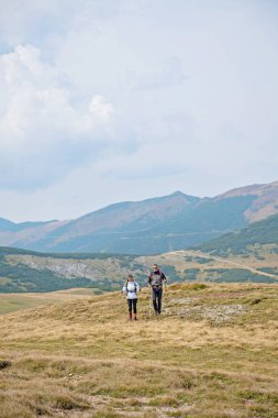 Sportif yürüyüşçü trekking direkleri ile yolda