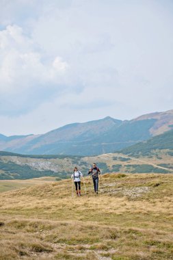 Sportif yürüyüşçü trekking direkleri ile yolda