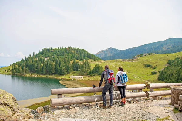 Genç çift backpackers yakın göl Dağları — Stok fotoğraf