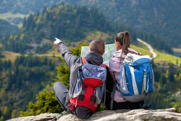 Smiling adventure couple with map on slope. look at map — Stock Photo, Image