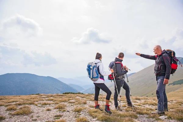 En äldre man som ger en rundtur för en ung grupp av människor — Stockfoto