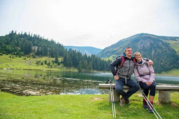 Genç çift backpackers yakın göl Dağları — Stok fotoğraf