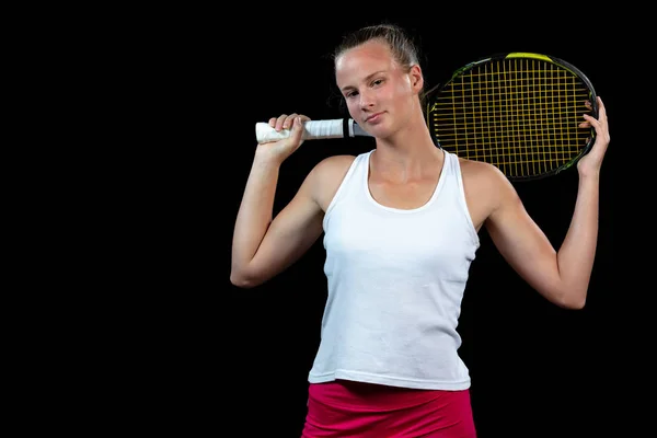 Atleta femenina posando con raqueta de tenis sobre fondo negro — Foto de Stock