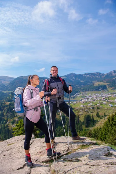 Turisté s batohy relaxaci na vrcholu hory a těší pohled do údolí — Stock fotografie