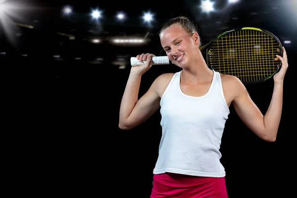 Ung kvinna på en tennis praxis. Nybörjare spelare håller en racket, lära sig grundläggande färdigheter. Porträtt på svart bakgrund. — Stockfoto