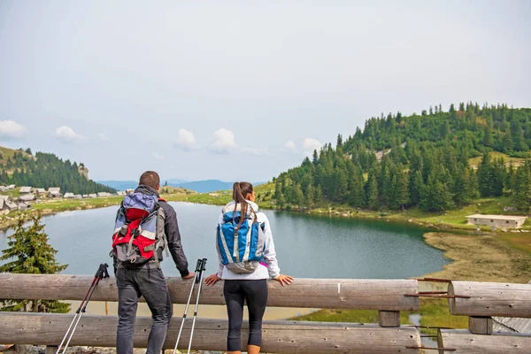 Genç çift backpackers yakın göl Dağları — Stok fotoğraf