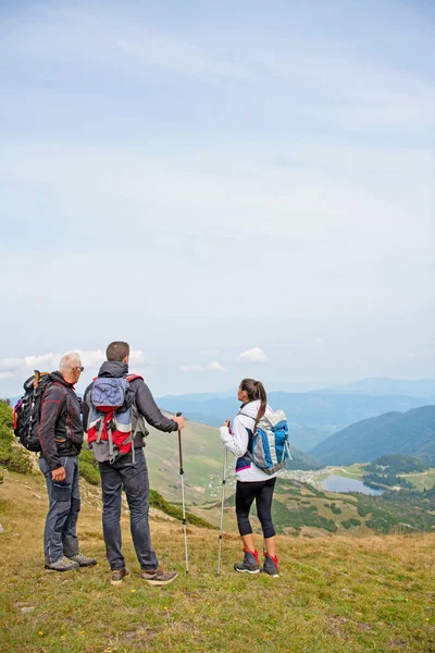 An elderly man giving a tour for a young group of people — Stock Photo, Image