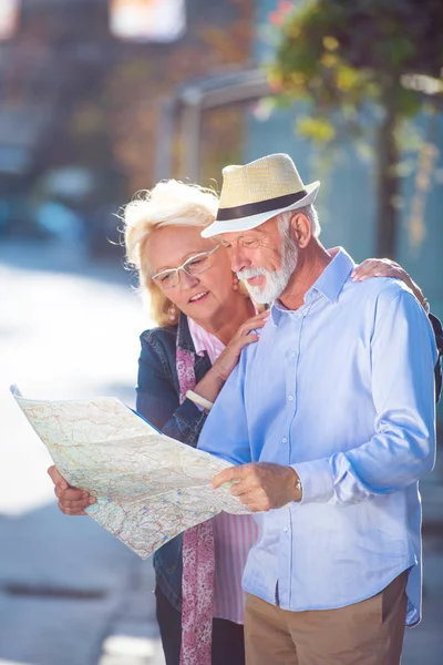 Pareja de turistas senior mirando el mapa de la ciudad —  Fotos de Stock