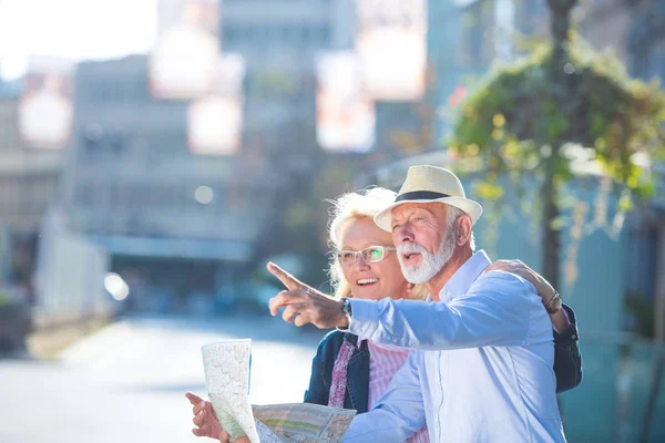 Pareja de turistas senior mirando el mapa de la ciudad —  Fotos de Stock