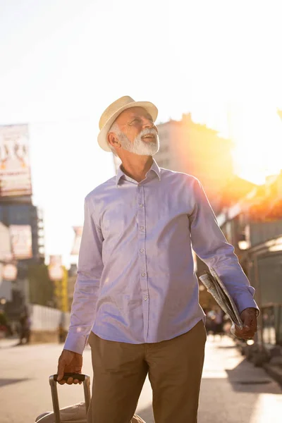 Feliz turista senior con maleta en la ciudad . —  Fotos de Stock