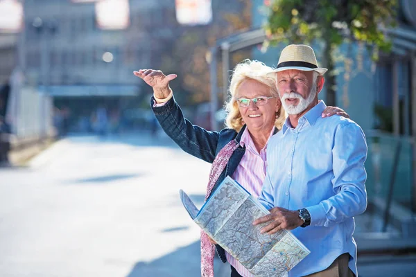 Pareja de turistas senior mirando el mapa de la ciudad —  Fotos de Stock