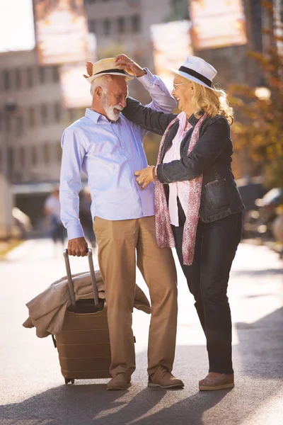 Feliz alegre pareja de turistas mayores con mapa y guía de la ciudad caminando por la calle —  Fotos de Stock