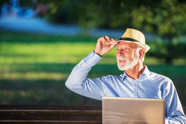 Hombre mayor usando computadora portátil en reposo en el parque al aire libre —  Fotos de Stock