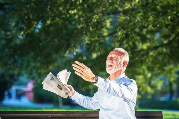 Hombre mayor relajándose en el parque en un día soleado sentado en un banco de madera y esperando a alguien —  Fotos de Stock