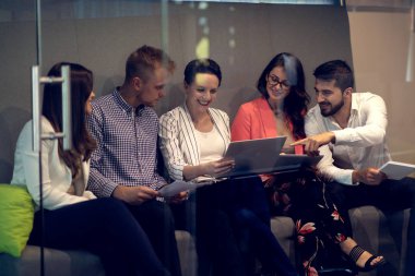 Modern ofis çok ırklı genç yaratıcı insanlar. Grup Genç iş adamları dizüstü bilgisayar, tablet, akıllı telefon, Not defteri ile birlikte çalışıyoruz.