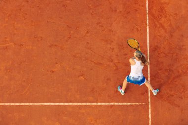 Maç sırasında sahada bir kadın tenisçi havadan çekilmiş. Tenis oynayan genç bir kadın. Yüksek açı görünümü.
