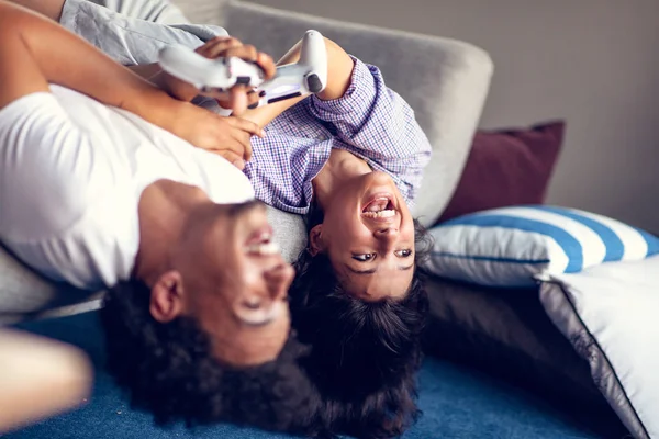 Jovem casal sorrindo jogando videogames em casa . — Fotografia de Stock