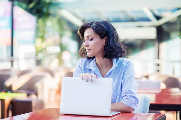 Contemplated young woman in cafe with laptop — Stock Photo, Image