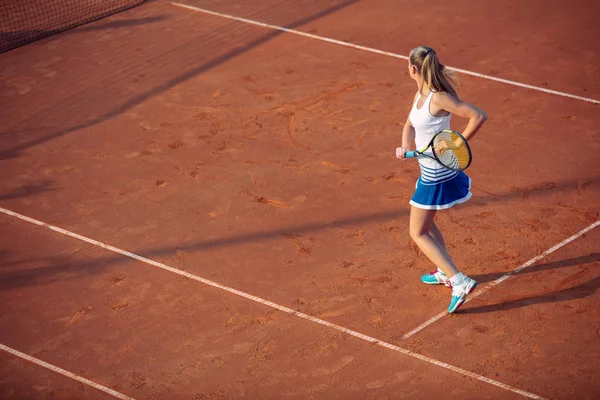 Kil üzerinde tenis oynayan genç bir kadın. Forehand. — Stok fotoğraf