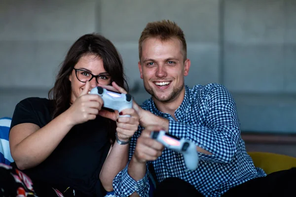 Joven pareja sonriente jugando videojuegos en casa . — Foto de Stock