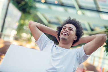 Parlak oturma odasında otururken diz üstü görünen galip yakışıklı adam