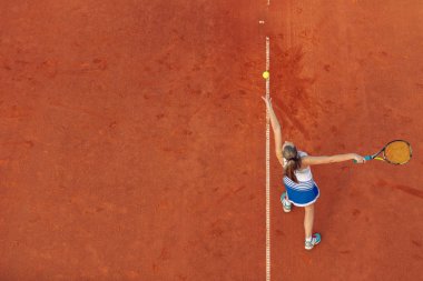 Maç sırasında sahada bir kadın tenisçi havadan çekilmiş. Tenis oynayan genç bir kadın. Yüksek açı görünümü.
